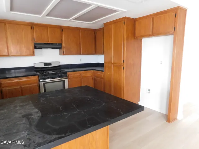 a kitchen with a sink a stove and a microwave