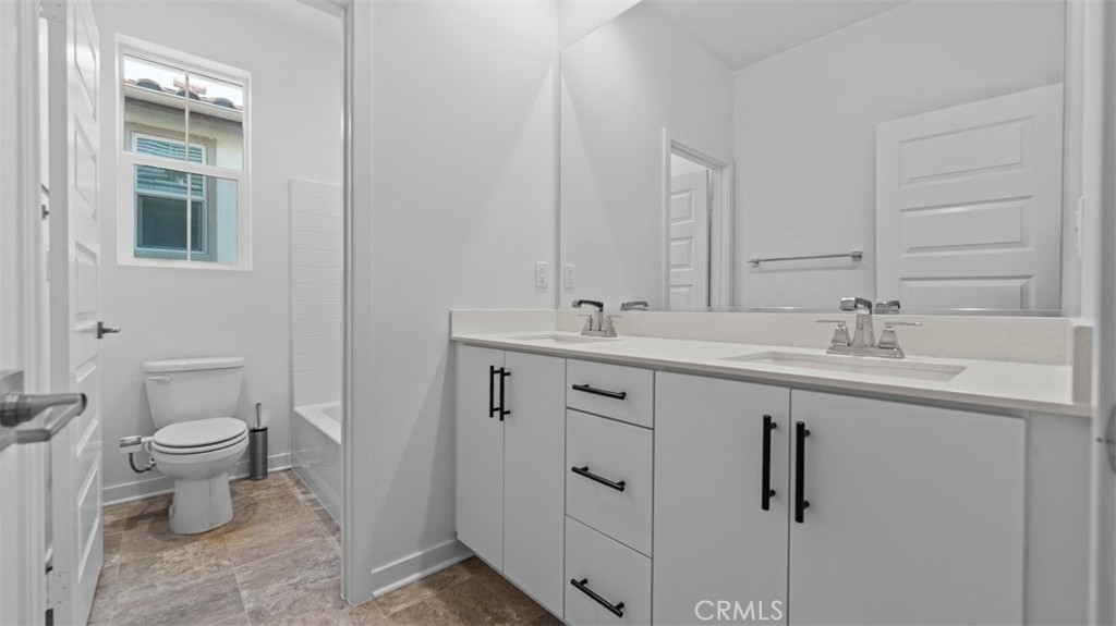 7044 Mallow Drive Mall, Unit 4 Fontana, CA 92336 - Photo 16 of 19 a bathroom with a toilet sink and mirror