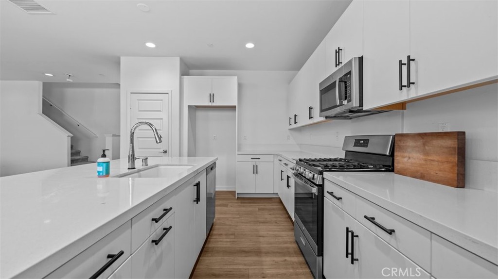 7044 Mallow Drive Mall, Unit 4 Fontana, CA 92336 - Photo 4 of 19 a kitchen with stainless steel appliances granite countertop a sink stove and refrigerator