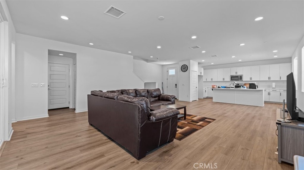 7044 Mallow Drive Mall, Unit 4 Fontana, CA 92336 - Photo 6 of 19 a living room with stainless steel appliances furniture wooden floor and a view of kitchen