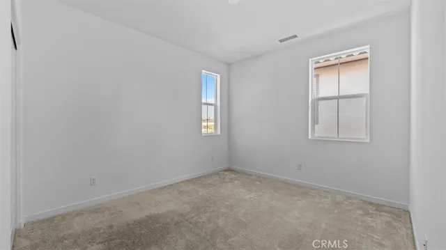 an empty room with windows and closet