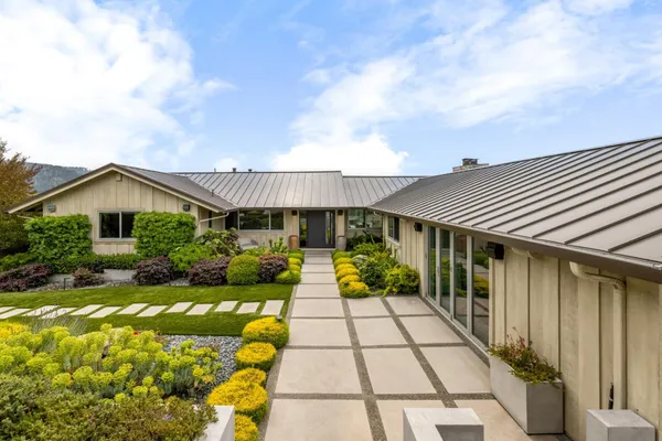 a front view of house along with deck and entertaining space