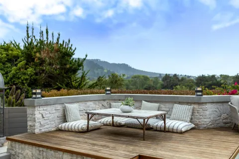 a view of a patio with couches table and chairs and potted plants