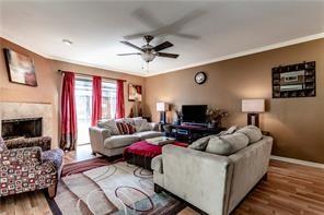 5626 Preston Oaks Road, Unit 39C Dallas, TX 75254 - Photo 26 of 38 Living room featuring wood finished floors, a ceiling fan, and a fireplace
