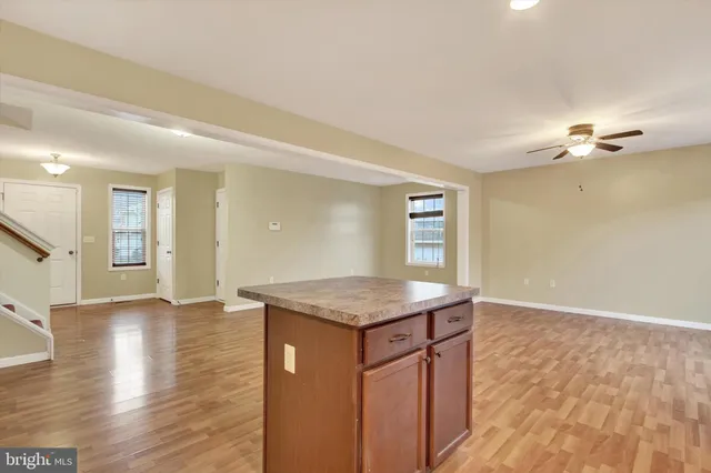 a kitchen with granite countertop a sink cabinets and wooden floor