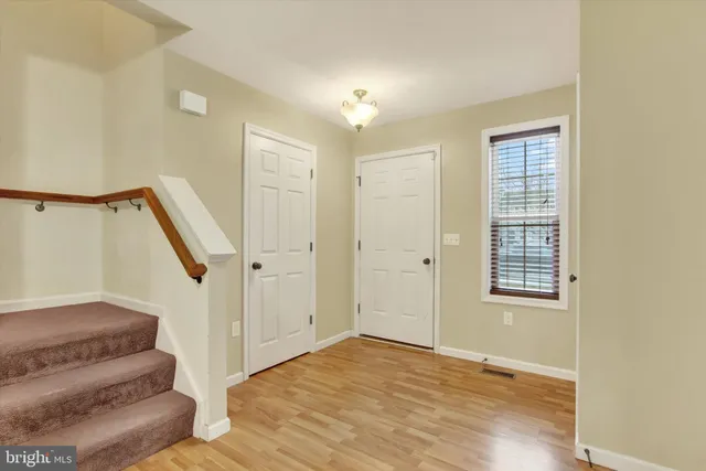 a view of entryway and hall with wooden floor