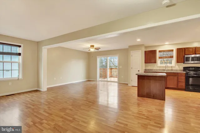 a view of kitchen with stove and wooden cabinets