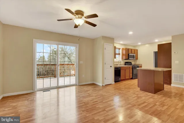 a view of kitchen with stainless steel appliances kitchen island wooden floor and window
