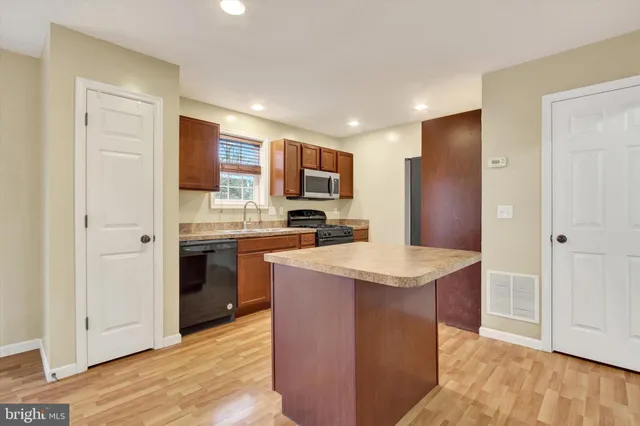 a kitchen with stainless steel appliances granite countertop a refrigerator stove top oven and sink