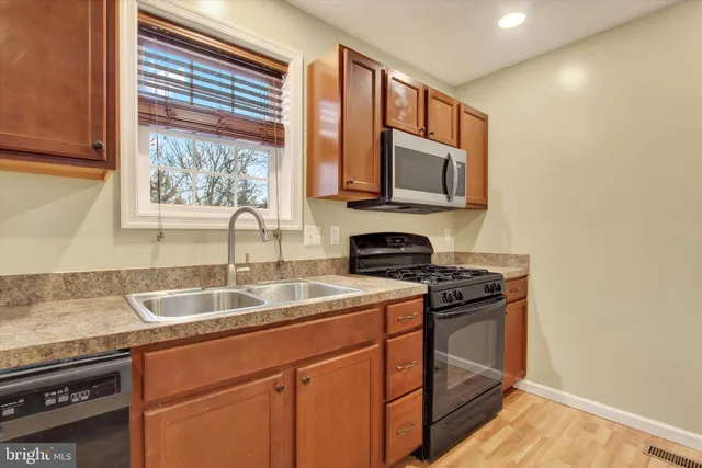 a kitchen with stainless steel appliances granite countertop a sink stove and microwave