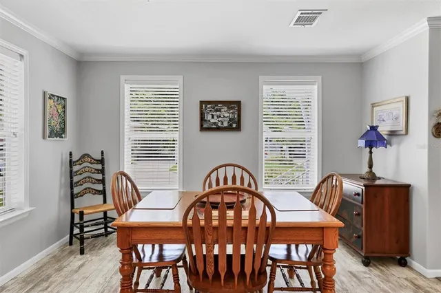 a view of a a dining room with furniture window and wooden floor