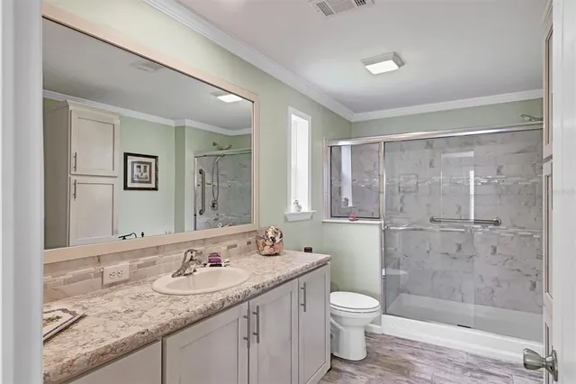 a bathroom with a granite countertop sink a toilet and shower