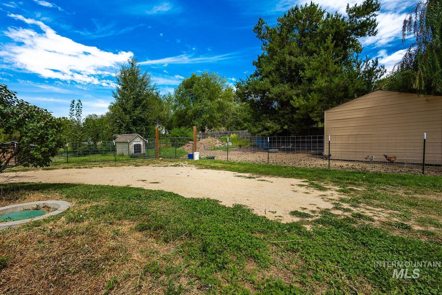 7166 South Cloverdale Road Boise, ID 83709 - Photo 46 of 50 Expansive grass lawn with mature trees and a gravel driveway
