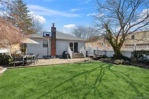 a view of a house with backyard and a tree