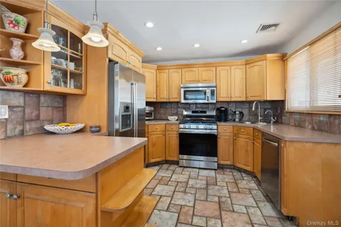 a kitchen with stainless steel appliances granite countertop a stove a sink and a refrigerator