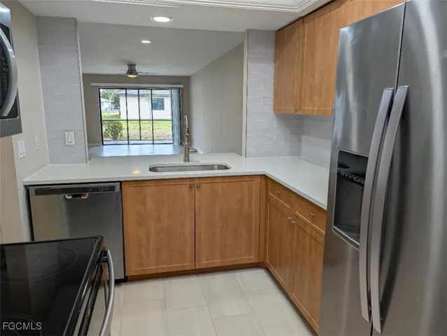 a kitchen with stainless steel appliances granite countertop a refrigerator and a sink