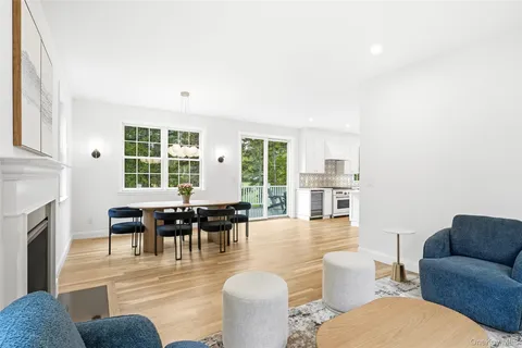 a living room with furniture a fireplace and a dining table with wooden floor