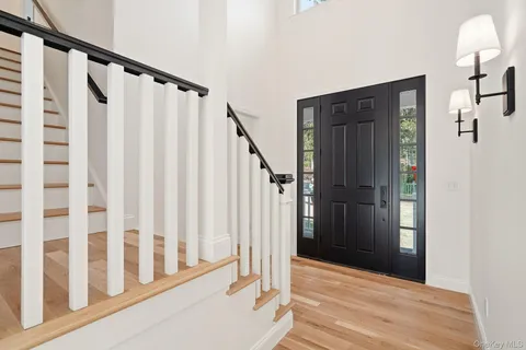 a view of a hallway with wooden floor and staircase
