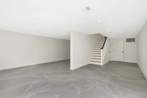 an empty room with a kitchen and entryway