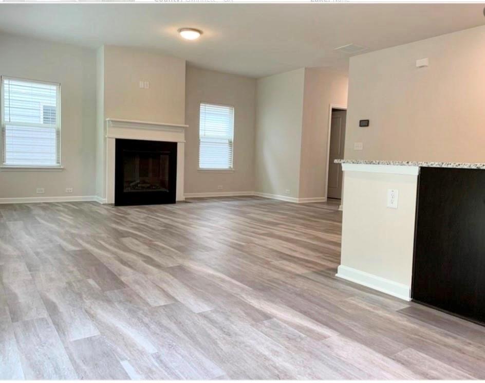 2979 Morgan Spring Trail Buford, GA 30519 - Photo 5 of 21 an empty room with wooden floor fireplace and windows