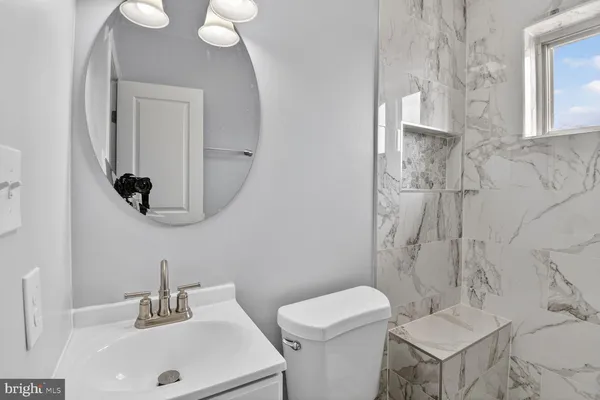 a bathroom with a toilet a sink and mirror