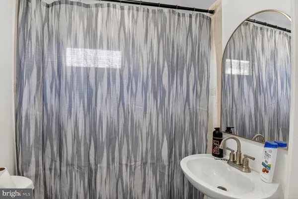 a bathroom with a sink a mirror and a shower curtain