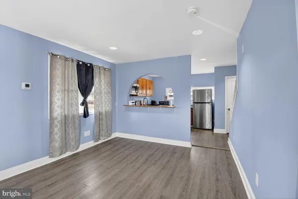 a view of empty room with wooden floor and entryway