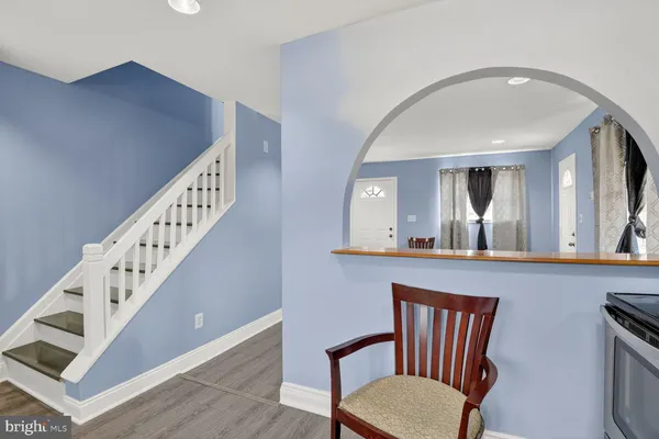 a view of a hallway with entryway and wooden floor