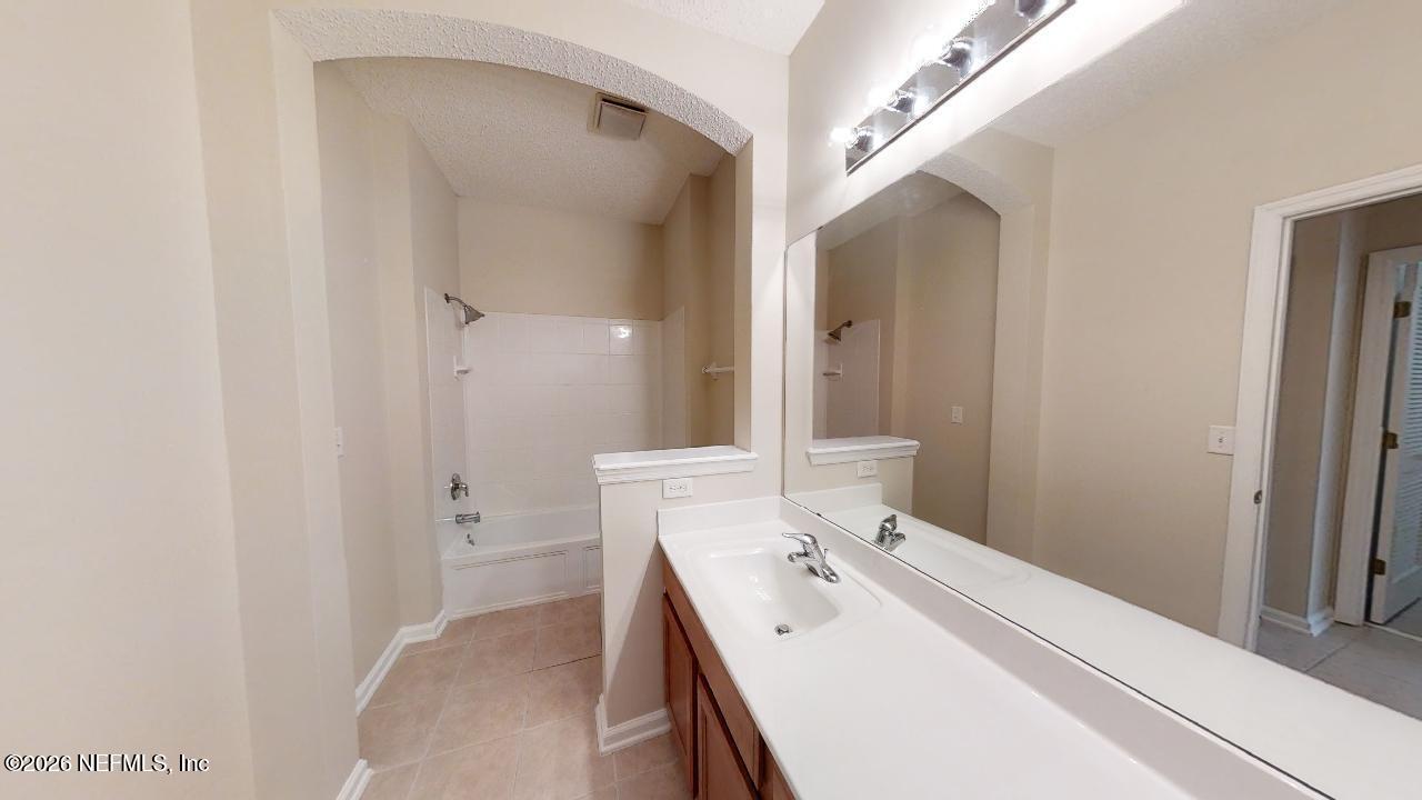 14454 Millhopper Road Jacksonville, FL 32258 - Photo 25 of 44 a en suite bathroom with a double vanity sink a mirror and a bathtub