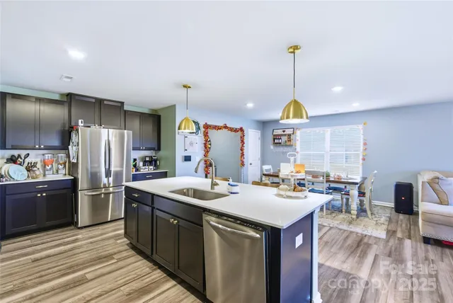 a kitchen with stainless steel appliances granite countertop a sink a stove and a refrigerator