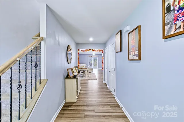 a view of a hallway with wooden floor and stairs