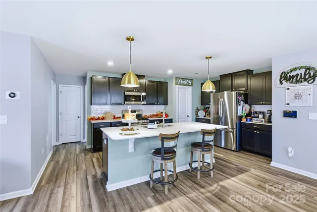 a kitchen with cabinets a counter and chairs in it