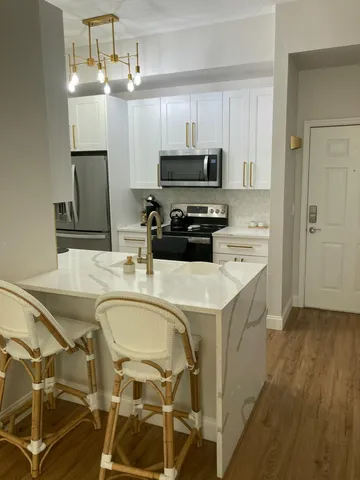 a kitchen with kitchen island a sink stainless steel appliances and cabinets