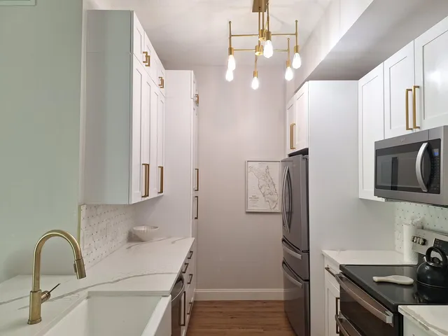 a kitchen with stainless steel appliances granite countertop a refrigerator and a stove top oven