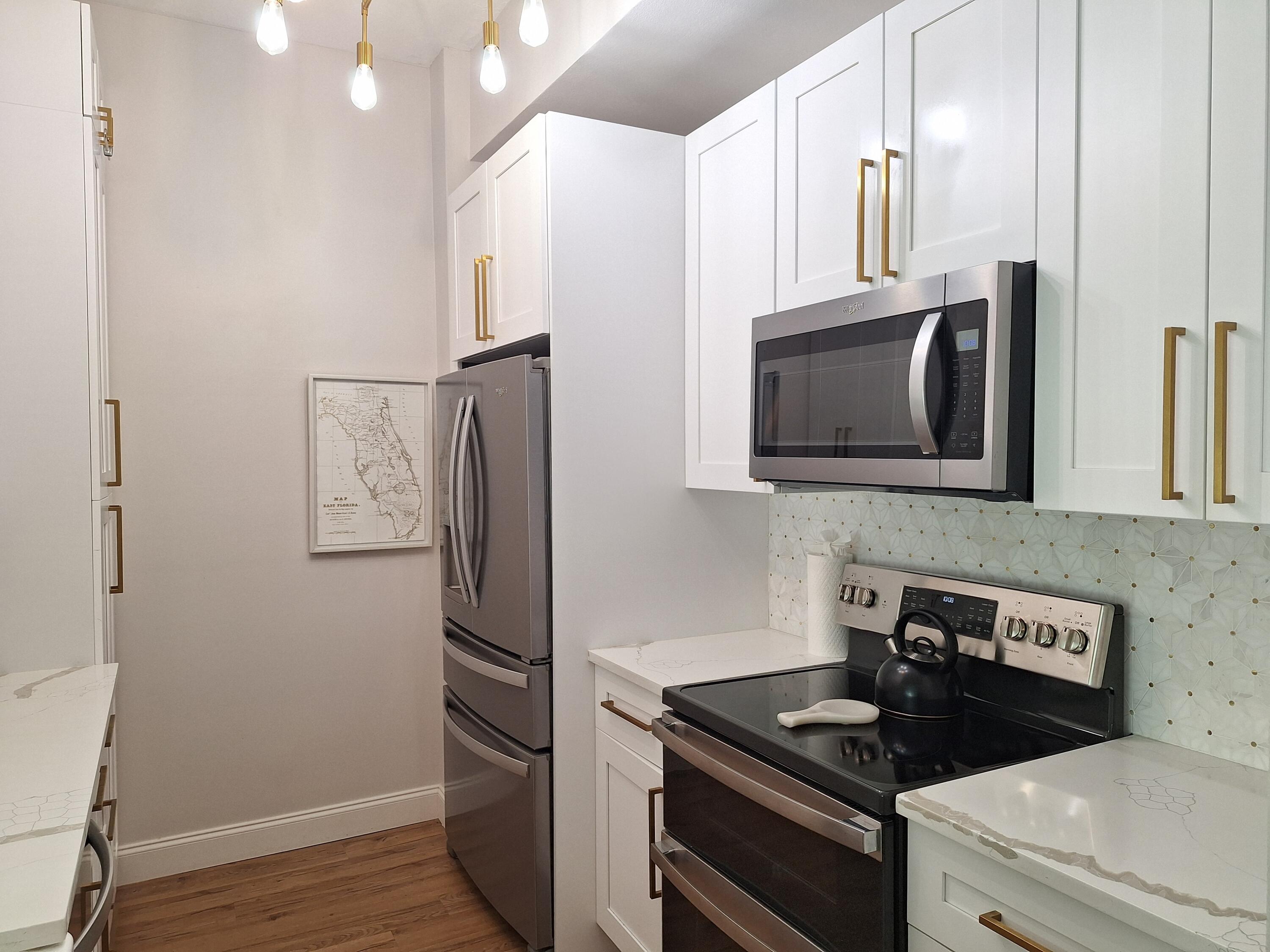 804 East Windward Way, Unit PH 21 Lantana, FL 33462 - Photo 15 of 46 a kitchen with stainless steel appliances granite countertop a refrigerator and a stove top oven