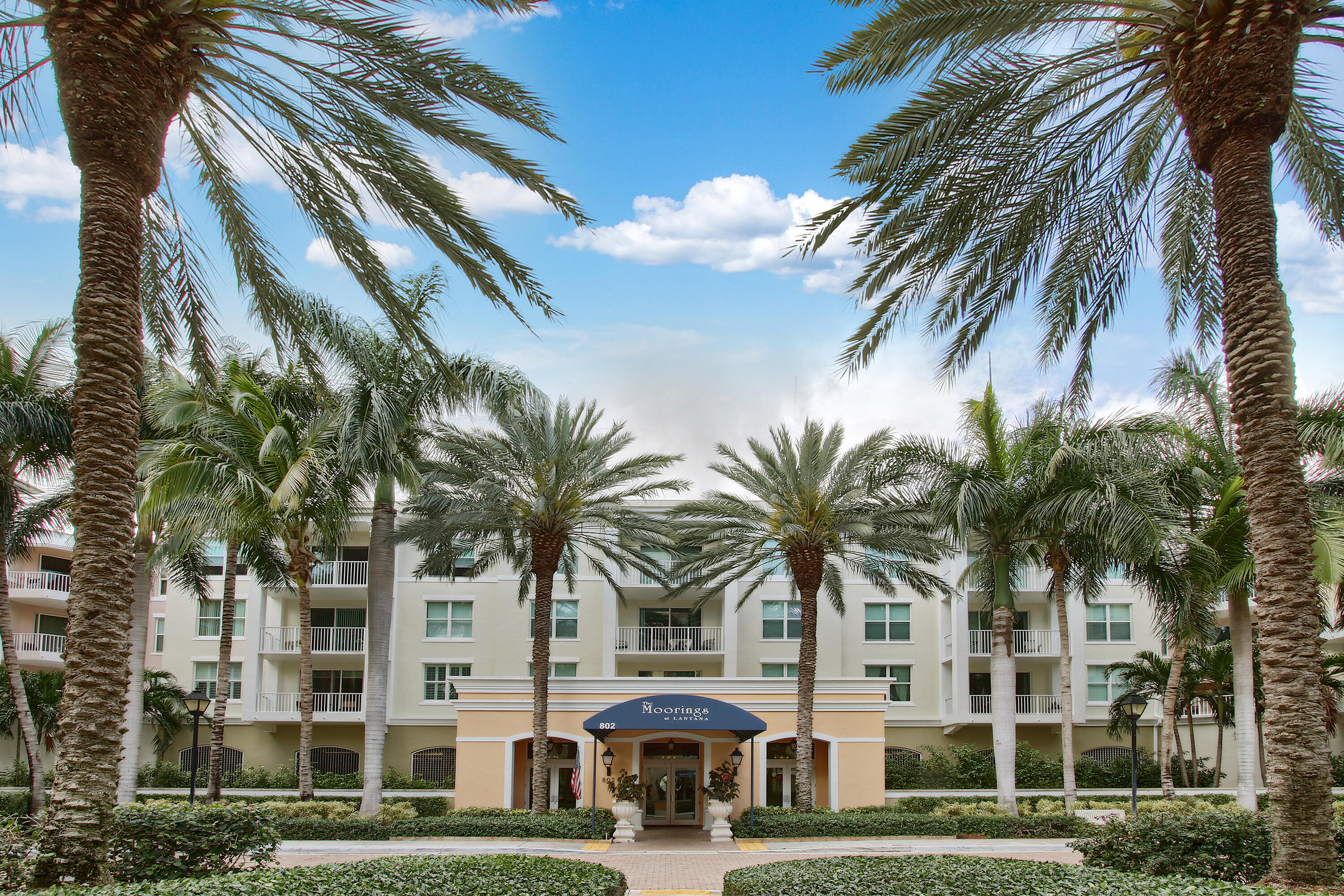 804 East Windward Way, Unit PH 21 Lantana, FL 33462 - Photo 46 of 46 a front view of multi story residential apartment building with yard and sign board