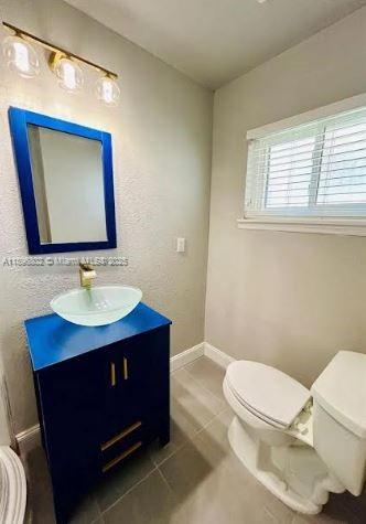 3147 Trevino Terrace, Unit 1 Punta Gorda, FL 33983 - Photo 15 of 48 a bathroom with a toilet a sink a mirror and a window