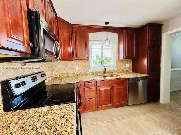 3147 Trevino Terrace, Unit 1 Punta Gorda, FL 33983 - Photo 8 of 48 a kitchen with stainless steel appliances granite countertop a stove a sink and a microwave