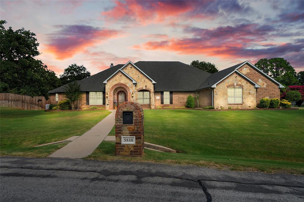 View of front of home with brick siding and roof with shingles