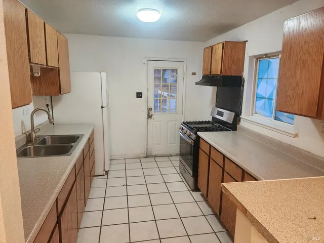 a kitchen with a sink a stove and a refrigerator