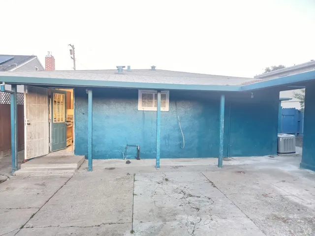a view of terrace with wooden fence and large trees