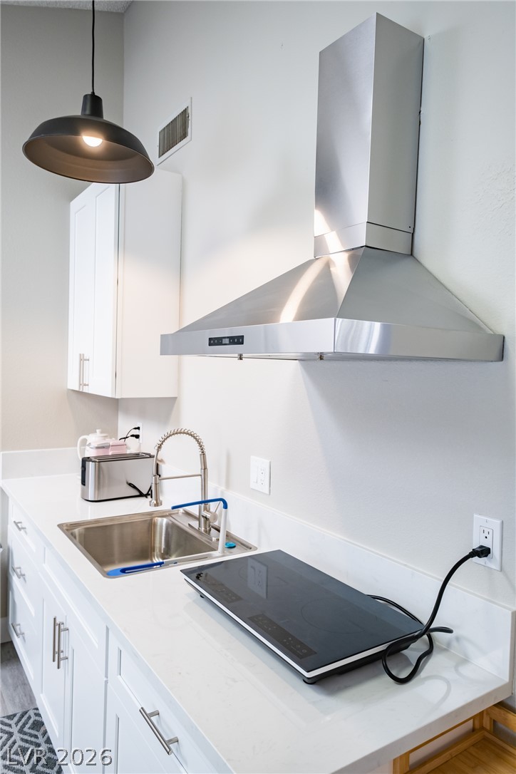 6356 West Viking Road Las Vegas, NV 89103 - Photo 29 of 51 Sleek countertops and a modern range hood anchor this functional kitchen prep space.