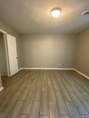en empty room with wooden floor and windows