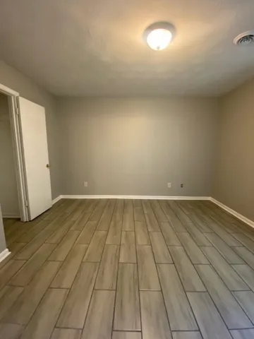 en empty room with wooden floor and windows