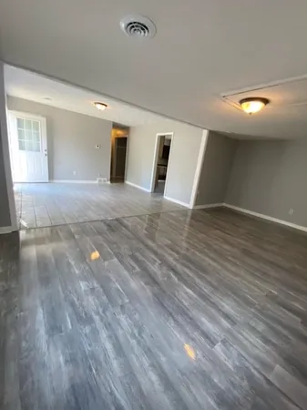 a view of a livingroom with wooden floor and window