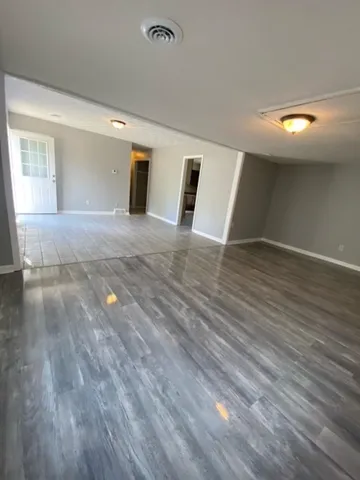 a view of a livingroom with wooden floor and window