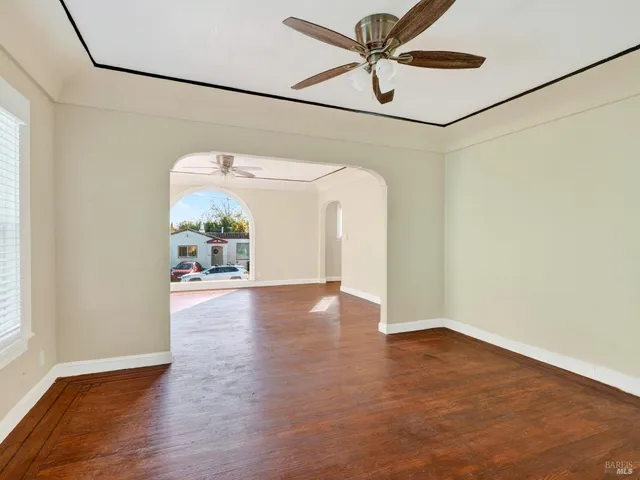 a view of a big room with wooden floor and windows