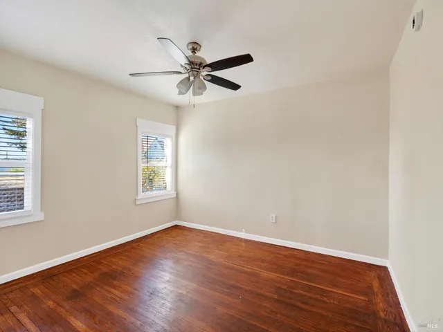 a view of a big room with wooden floor closet and windows