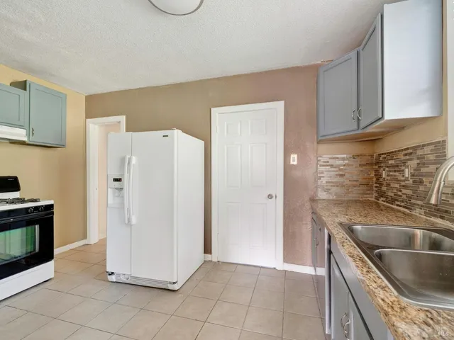 a kitchen with a refrigerator sink and cabinets