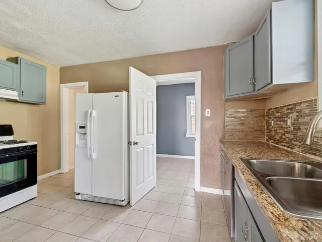 a kitchen with a refrigerator sink and cabinets